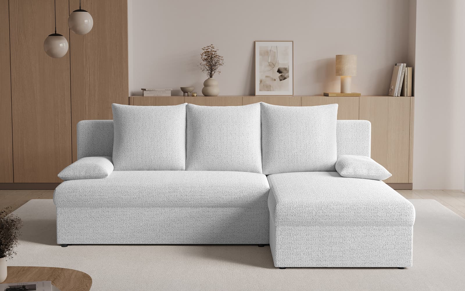 Light gray L-shaped sofa with chaise in a modern living room with beige walls and wooden cabinetry.